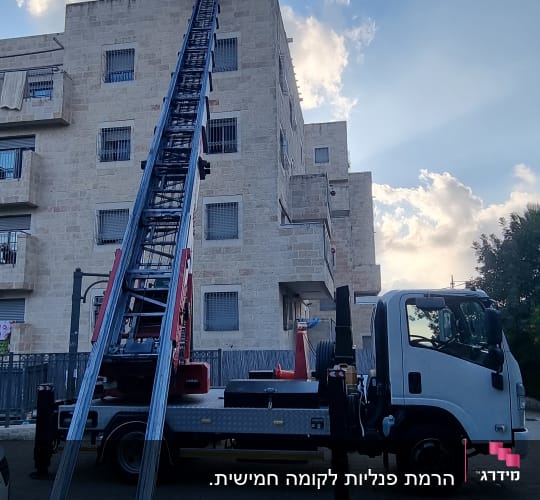 מנוף על משאית ליד בניין מגורים